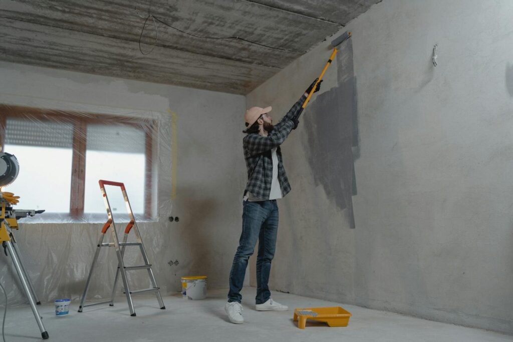 Un homme peint un mur intérieur